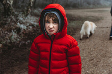 Boy In Red Winter Coat Looking At Camera And Snarling Curling Up Nose