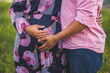 © Cavan Images - Couple expecting a baby. A man and a woman hold stomachs .