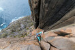© Cavan Images - Female adventurer and rockclimber makes her way up the dolerite sea cliffs of Cape Raoul, Tasmania, Australia.
