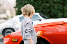 Little Boy In Sweater Washing A Classic Car Outside In Spring