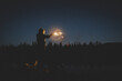 © Cavan Images - Tween  Boy's Face Is illuminated by a glowing sparkler at Twilight