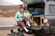 © Cavan Images - Smiling young woman sitting with dog in trunk of off-road vehicle during snowfall