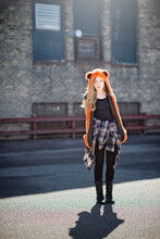 Teen Girl With Long Hair In Orange Spirit Hood, Backlit, In City.