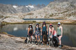 © Cavan Images - Smiling female friends with dogs standing at Titcomb Basin on sunny day
