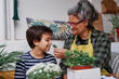 © Cavan Images - Child smells a plant with his Mother in the home garden in spring