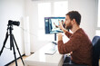 © Cavan Images - Young bearded man streaming online and vlogging
