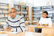 © JackF - Interested Latin American adult engaged in research, looking for information in books in public library