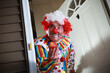 © soupstock - Awkward man dressed in a clown costume handing out apples for trick or treat