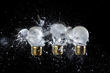 Wall Mural - explosion of 3 light bulbs on the white background.