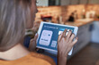 © Westend61 - Woman adjusting air conditioner through digital tablet at home