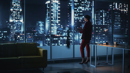 Poster - Successful Powerful Businesswoman Wearing Stylish Suit Holding Laptop Standing in Big City Night Office. Female CEO Managing Environmental, Social and Corporate Governance for e-Commerce Empire
