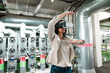 © Westend61 - Female expert gesturing while using virtual reality headset in industry