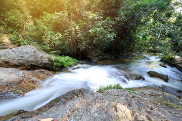 Wall Mural - Long exposure of river stream through rocks with motion blur effect .