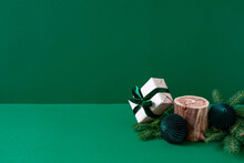 Christmas Mockup For Eco Cosmetic Advertising. Empty Wooden Podium, Present Wrapped In Craft And Velvet Ribbon, Natural Fir Tree Branches, Paper Decorations On Green Background. Copy Space, Front View