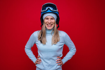 Wall Mural - Portrait of a smiling young woman in a sweater, helmet and ski goggles
