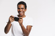 © Drobot Dean - Young black man smiling while playing online game on cellphone