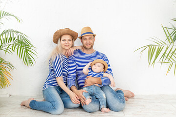 happy family mother, father and baby in a nautical image in vests and hats, the concept of travel and recreation