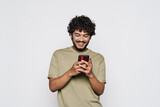 Fototapeta  - Young bearded man dressed in t-shirt using mobile phone