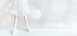 Legs of a doll in a white dress and shoes on a white background in the format of a banner