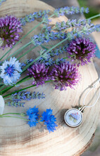 Cornflowers, Lavender And Leek With Pendant On Wooden Table