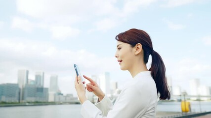 Poster - 都市を背景にスマホを持つ女性