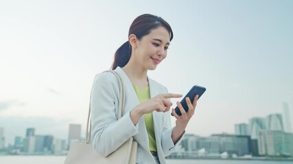 Poster - 空を背景にスマホを見る女性