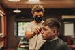 © Westend61 - Young man getting haircut by male barber in salon during COVID-19 outbreak