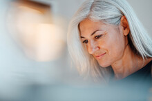 Mature Businesswoman With White Hair Looking Down At Office