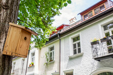Germany, Bavaria, Munich,Birdhouse Hanging In Front Of Old Townhouses