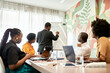 © Westend61 - Businessman explaining business strategy on white board to colleagues at coworking office