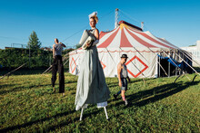 Circus Artists Performing While Walking On Meadow