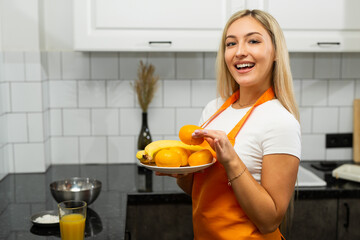 portrait of cute caucasian woman in apron with a plate of fruit 