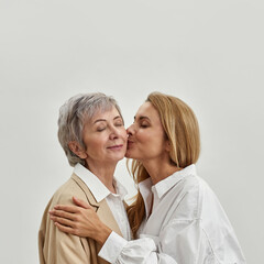 Wall Mural - loving grownup daughter kiss mature mom in cheek