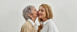 Banner shot of loving old mom kiss grownup daughter