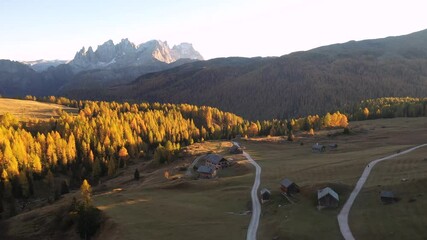 Wall Mural - drone flyght over fuchiade valley in italian dolomites countryside in autumn time. wooden huts, oran