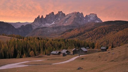 Wall Mural - incredible red sunset at fuchiade valley in italian dolomites countryside. wooden huts, orange larch