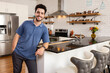 © SuperStock - Portrait of young man standing in kitchen of his new apartment looking at camera, smiling.