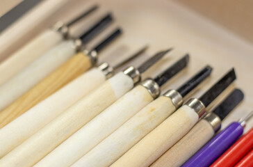 little chisels in a wooden box, on a shelf in a art store. wooden material stick and iron top. art shop, pictor, master, inspiration.