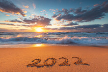 Happy New Year 2022 Text, Lettering On The Beach Sand At Sunrise.