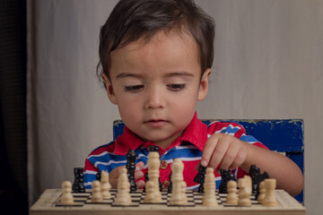 portrait of little boy playing chess