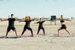 © Samuel Perales - Yoga teacher conducting a class with multiethnic people on a beach