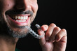 bearded guy putting on transparent dental retainer