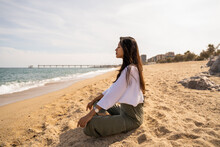 Beautiful Young Woman Sitting Relaxing At Beach