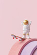 © Yaroslav Danylchenko/Stocksy - Spacemen riding skateboard on pink background