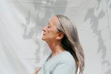 Grey-haired Woman Posing On Profile In Sunlight