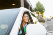 © ByLorena/Stocksy - Smiling woman driving white SUVs modern car