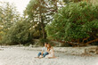 © Luke Liable/Stocksy - Young couple sitting on a beach