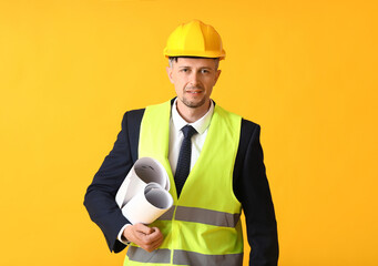 Male architect with drawings on color background