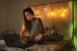 © Eloisa Ramos/Stocksy - Teenager and laptop at cozy room