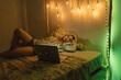© Eloisa Ramos/Stocksy - Teen girl watching movie at bedroom